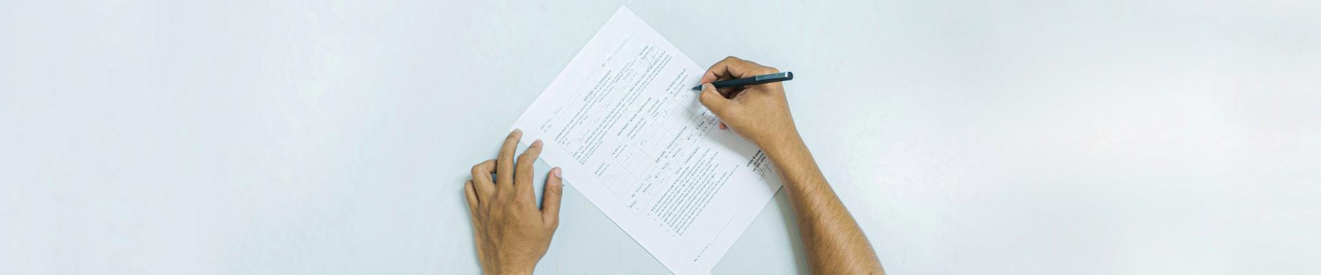 A person filing a form at his table