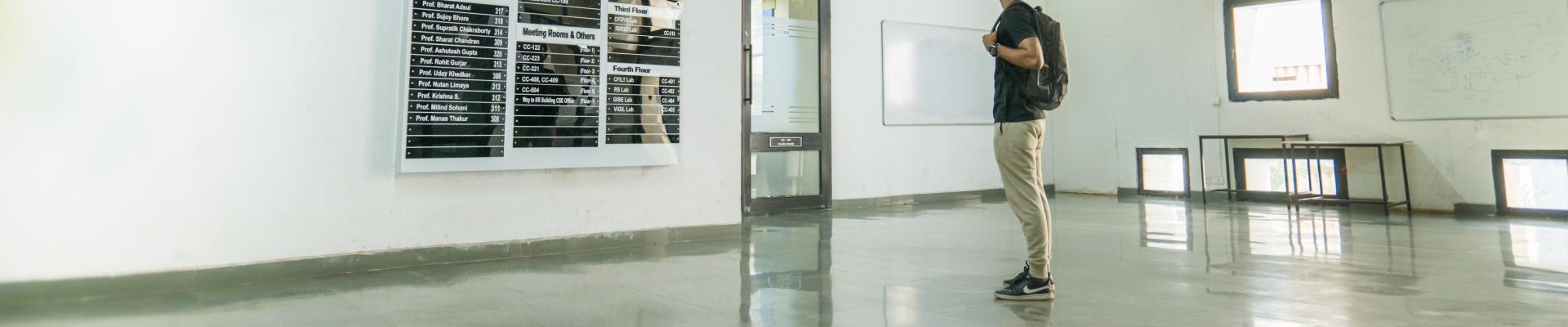 A student looking at a chart of faculty names