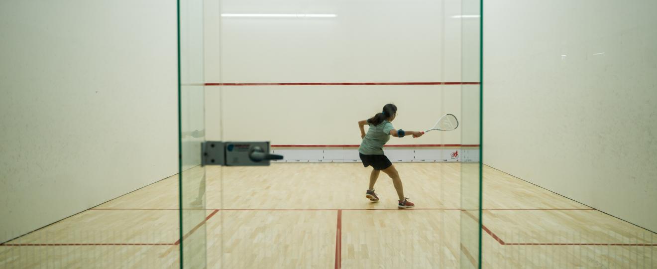 A student playing squash