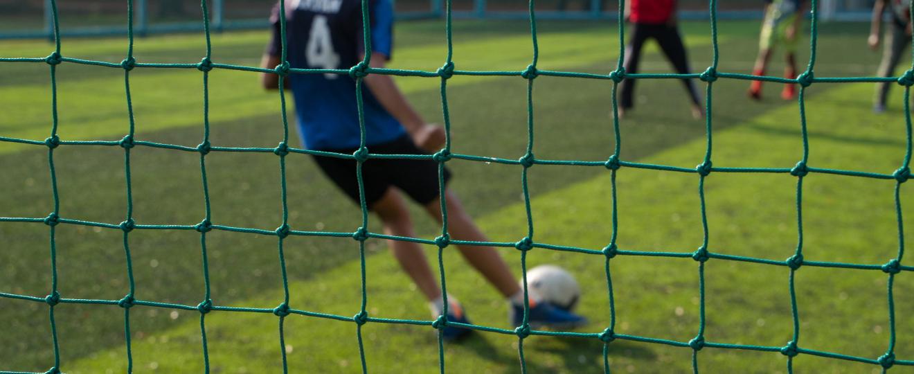 A student playing football on football turf